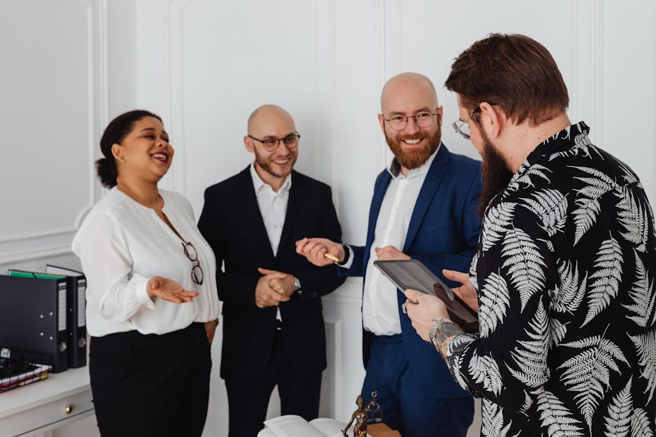 A diverse group of business professionals smiling and discussing ideas in an office setting.
